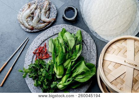 Asian Cooking Ingredients: Rice Papper, Pok Choy, Sauces, Raw Shrimps. Asian Food Concept Chinese Or