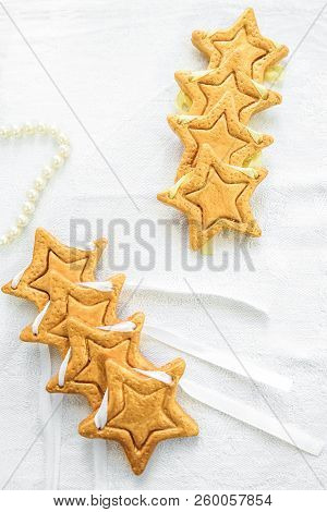 Two Rows Decorative Golden Stars Handmade From Dough On A White Fabric Surface