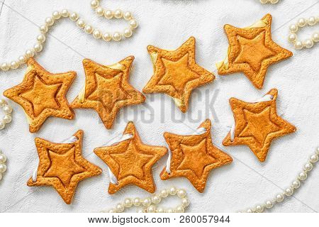 Two Rows Of Eight Decorative Golden Stars Handmade From Dough On A Bright White Fabric Surface With 