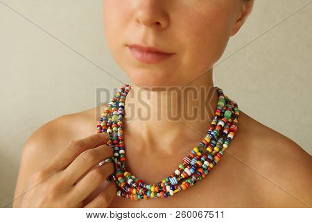 Bright Beads Of Murano Glass On A Young Girl. The Girl's Hand Touches The Beads