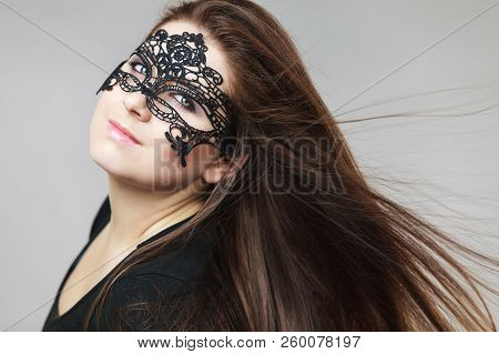 Pretty Mysterious Woman Wearing Black Eye Lace Mask Having Tousled Windblown Long Brown Hair.