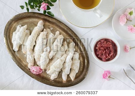 Traditional Romanian Or Moldavian Shortcake Cookies With Jam Stuffing And A Cup Of Tea On The Light 