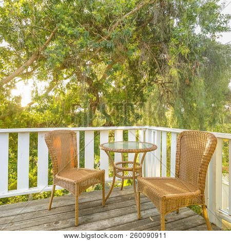 Sunlit Balcony With Wooven Chairs And Table