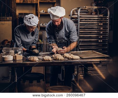 Chef Teaching His Assistant To Bake The Bread In A Bakery.