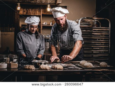 Chef Teaching His Assistant To Bake The Bread In A Bakery.