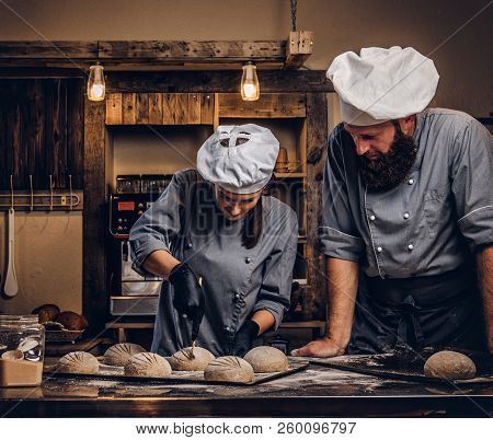 Cooking Master Class In Bakery. Chef With His Assistant Showing Ready Samples Of Baking Test In Kitc
