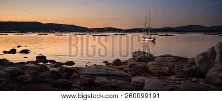 Landscape With A Sailboat Sailing At Sunset On The Shores Of An Island Galicia, Spain