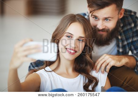 Happy Young Married Couple Photographed, Makes Selfie In A New Apartment