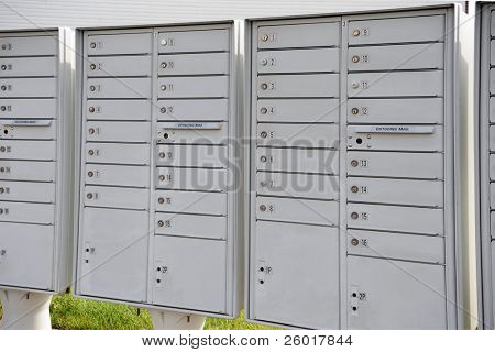 Empilements de plusieurs récipients de courrier verrouillé avec des fentes pour le dépôt de courrier, tous situés à l'extérieur.