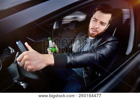 Drinks alcohol in the car. The guy with beer at the wheel. Man with beer. emergency situation. Socia