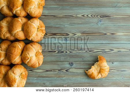 Rows Of Freshly Baked Croissants In A Side Border With A Single Half Eaten Croissant To The Side On 