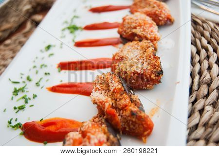 Five Little Eggplants On Rectangular White Plate And Pieces Of Parsley