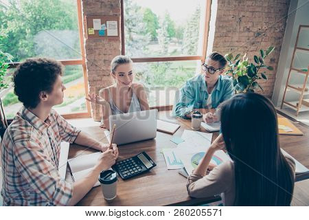 Stylish Diversity Youngster In Trandy Casual Wear Sits At The Wooden Table With The Calculator And D