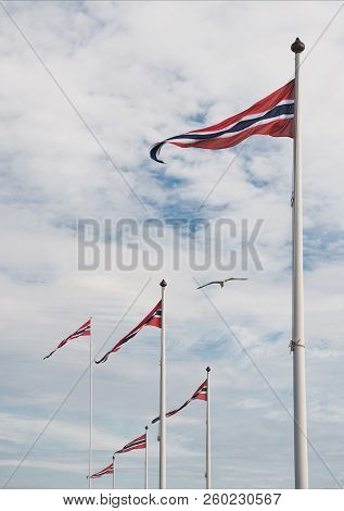 Low Angle View Of Norwegian Flags Against Cloudy Sky, Hamar, Hedmark, Norway
