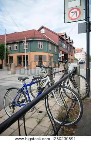Parked Bicycles With Building Behind At City Street, Hamar, Hedmark, Norway