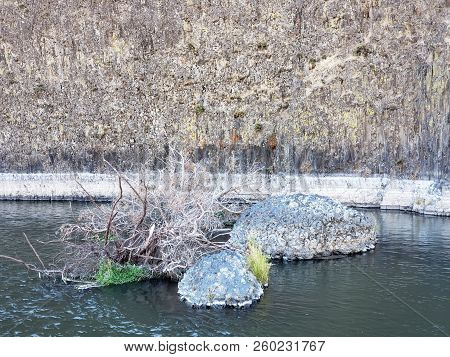 The Beautiful Crooked River With Fall Colored Bushes On Its Banks Flows Through A Canyon Formed From