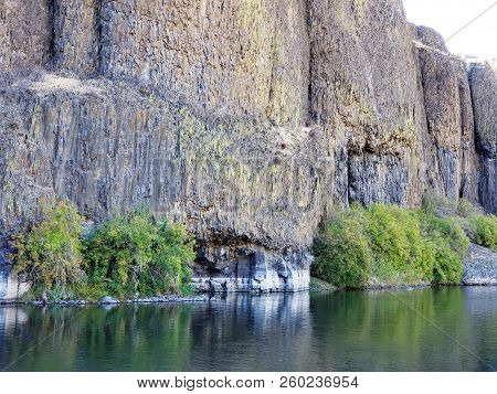 The Beautiful Crooked River With Fall Colored Bushes On Its Banks Flows Through A Canyon Formed From
