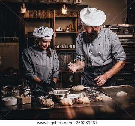 Chef Teaching His Assistant To Bake The Bread In A Bakery.