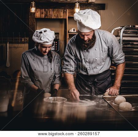 Chef Teaching His Assistant To Bake The Bread In A Bakery.