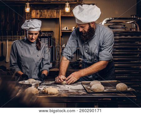Chef Teaching His Assistant To Bake The Bread In A Bakery.