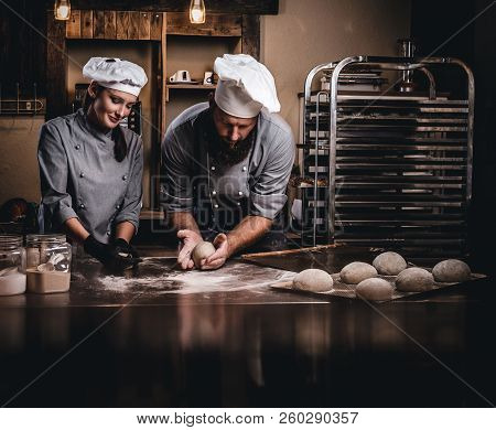 Chef Teaching His Assistant To Bake The Bread In A Bakery.