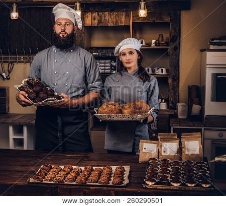 Chef With His Assistant Showing Fresh Bread In The Kitchen. Promotion In Bakery.
