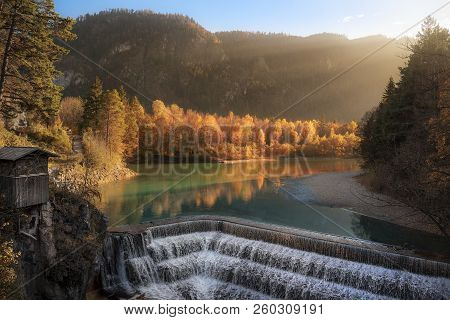 Enchanting Fall Scenery With An Old Cabin, The Stairs Of The Lechfall Waterfall, The River Lech And 