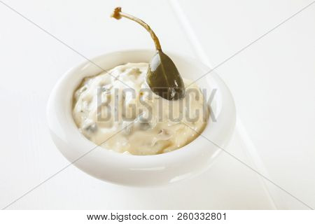 A Small Bowl Of Homemade Tartare Sauce With A Caperberry.