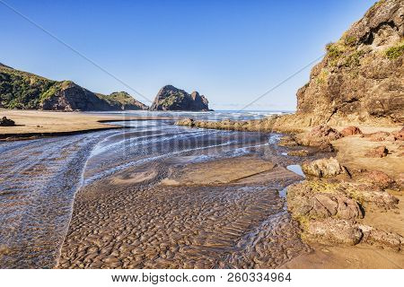 Piha Beach At Low Tide, With Deeply Textured Sand In The Stream Bed.