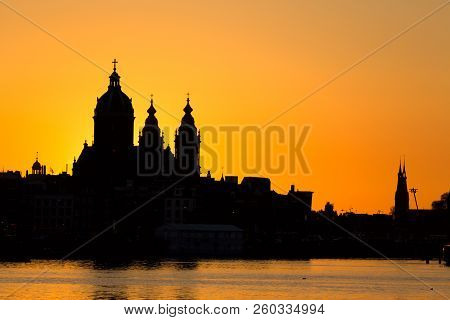 Amsterdam Cityscape Skyline With Church Of Saint Nicholas Sint-nicolaaskerk During Sunset. Picturesq