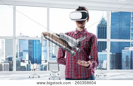 Young Caucasian Woman In Modern Office Interior Trying Virtual Reality Helmet And Viewing Space Shut