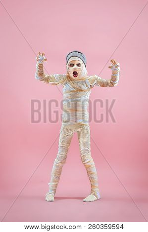 Studio Image Of A Young Teen Girl Bandaged, On Pink Background. Bloody Halloween Theme: The Crazy Ma