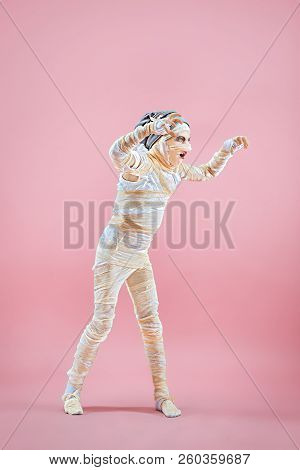 Studio Image Of A Young Teen Girl Bandaged, On Pink Background. Bloody Halloween Theme: The Crazy Ma