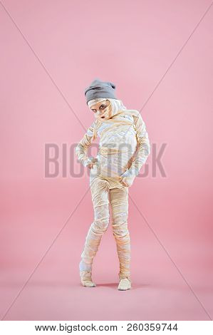 Studio Image Of A Young Teen Girl Bandaged, On Pink Background. Bloody Halloween Theme: The Crazy Ma