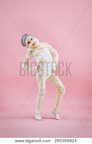 Studio Image Of A Young Teen Girl Bandaged, On Pink Background. Bloody Halloween Theme: The Crazy Ma