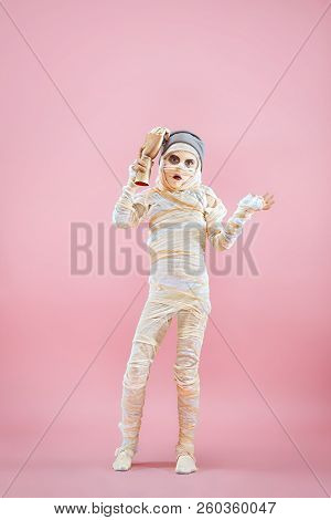 Studio Image Of A Young Teen Girl Bandaged, On Pink Background. Bloody Halloween Theme: The Crazy Ma