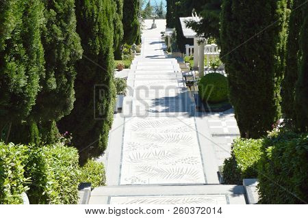 Marble Staircase Leading To The Sea Along The Cypress Trees In The Park On A Sunny Day