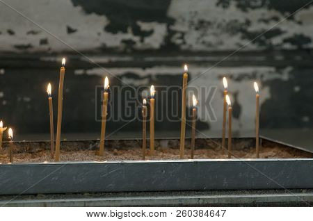 Candles Burning At Church. Side View. Horizontal. Tilted.