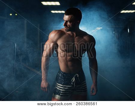 Strong Fitness Man Shows His Athletic Body In The Gym. The Concept Of A Healthy Lifestyle