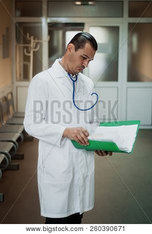 Young Doctor Looking At A Folder In The Hospital