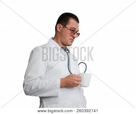 Young Male Doctor With A Mug In His Hand Looks Thoughtfully
