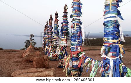 Vivid Colored Ribbons Hadak Tied On Posts Of Wish. Wooden Ritual Pillars. Sacred Place Of Buddhist S