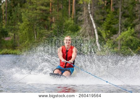 Young Athletic Man Riding Kneeboard On A Lake