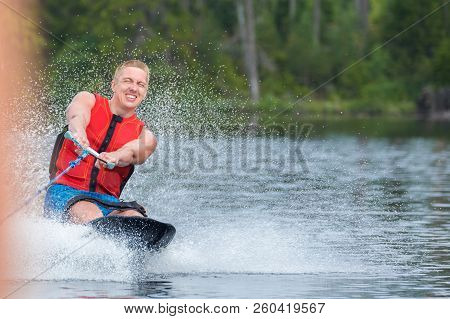 Young Athletic Man Riding Kneeboard On A Lake