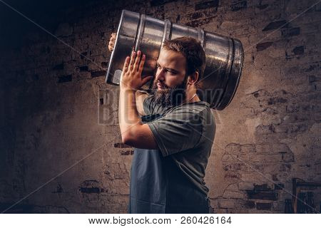 Brewer In Apron Holds Barrel With Craft Beer At Brewery Factory.