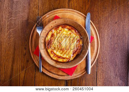 Sweet Rice Pudding Baked In Pottery With Fork And Knife