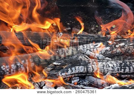 Beautiful Red Flame From Slice Wood, Dark Grey Black Coals Inside Metal Brazier. Wood Burning In The
