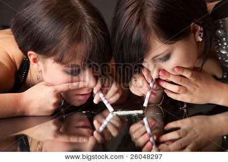 meninas estão cheirando cocaína (imitação). isolado em um fundo preto