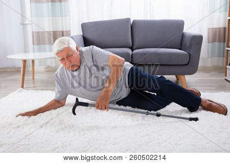 Senior Man Fallen On Carpet With Walking Stick