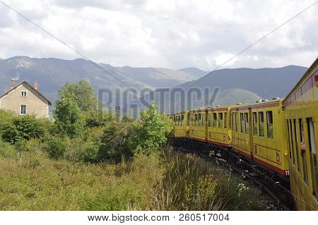 Latour De Carol - September 4, 2018: The Small Yellow Train Of The Pyrenees Crossing A Beautiful Mou